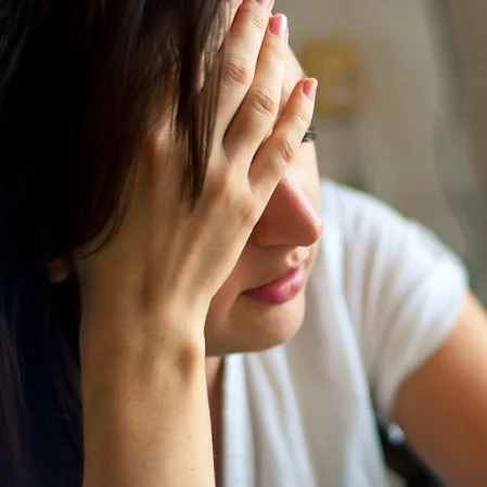 Person holding their head in pain.
