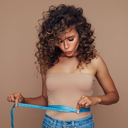 Woman measuring her waist.